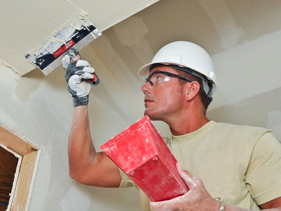 Finisher applying joint compound to a drywall seam with a wide knife